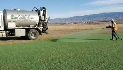 Hydroseeder truck spraying green slurry on new lawn in Salt Lake City UT by Chop Chop Landscaping